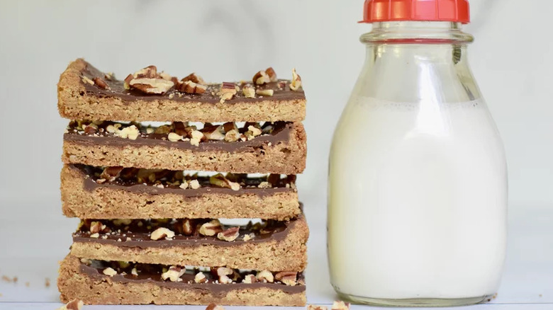 Brown cookie bars with chocolate and nuts, with milk bottle.
