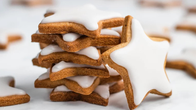 Stack of star-shaped cookies with white icing.