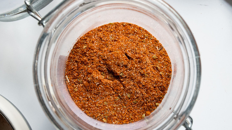 Red fajita spice blend inside of glass jar.