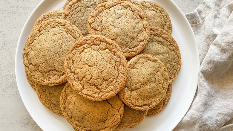 Plate full of round, crinkled molasses cookies. 