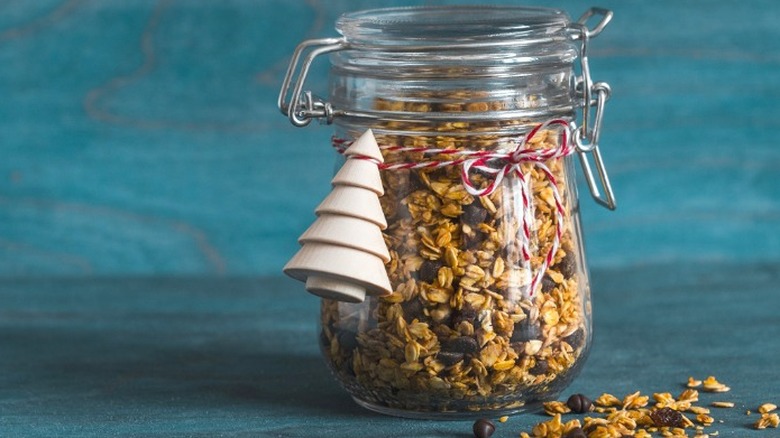 Granola mixture in glass jar with tree-shaped ornament.