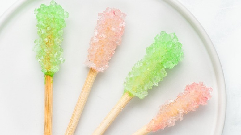 Sticks of pink and green candy on a white plate.