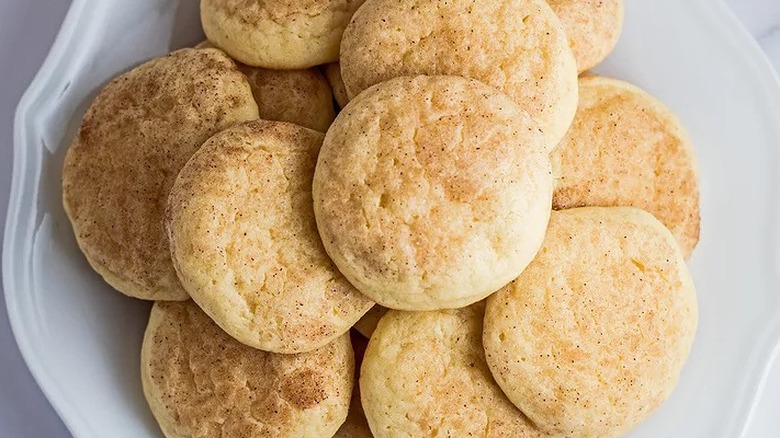 Round sugar cookies with cinnamon-speckled tops.