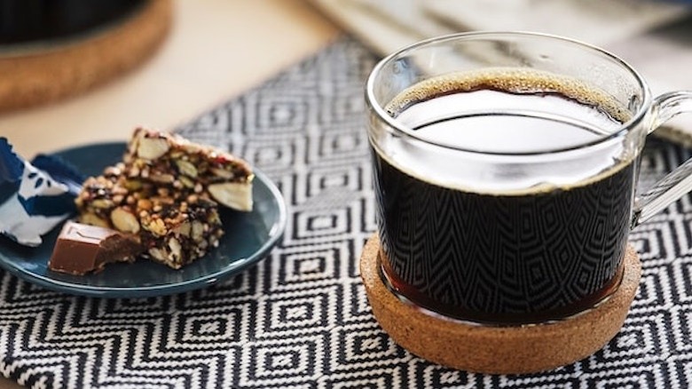 Cup of coffee with a piece of cake on a small plate