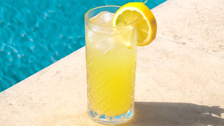 Glass of lemonade by pool 