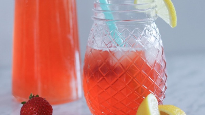 Red fruit drink in glass with lemons