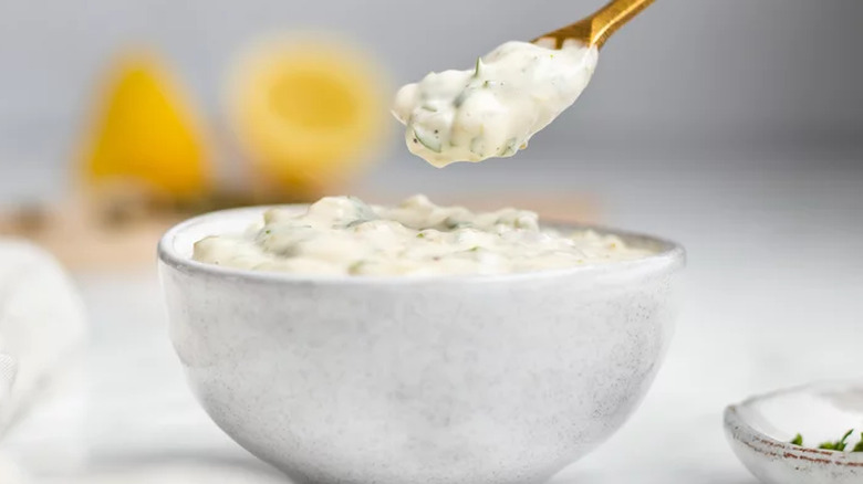 White bowl and spoonful of thick tartar sauce