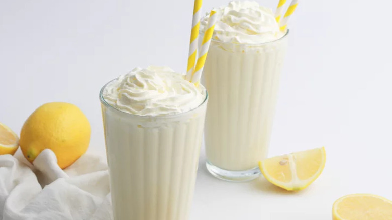 Tall glasses of creamy lemon drink with straws