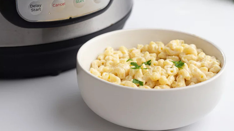 Bowl of mac and cheese next to an Instant Pot.