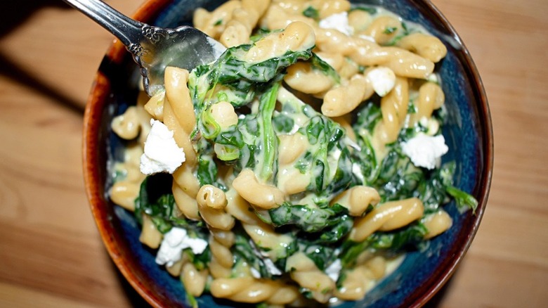 Bowl of pasta with cheese sauce and spinach