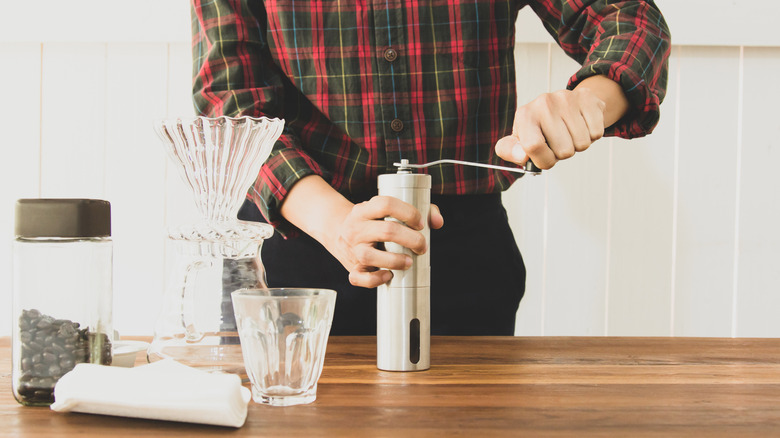 Barista using manual coffee grinder