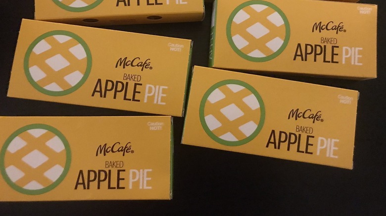 Numerous McDonald's apple pie boxes on black