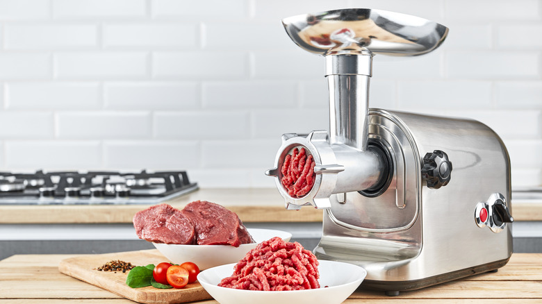 Meat grinder grinding beef