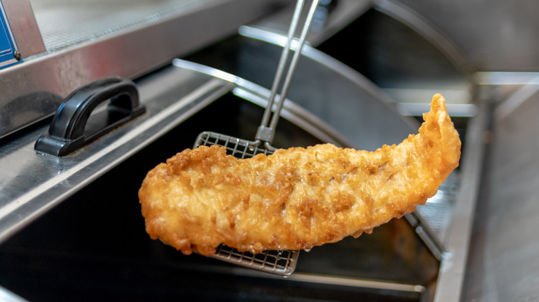 Fried fish being removed from fry oil