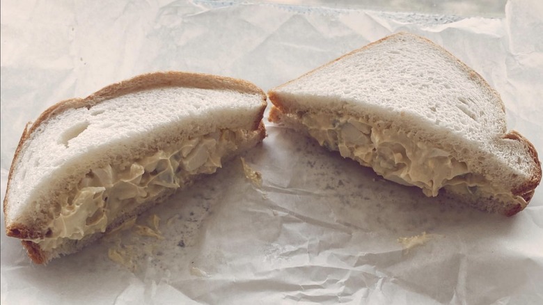 Diagonal cut egg salad sandwich on white bread