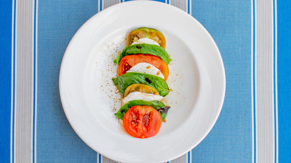 Caprese salad on plate with blue tablecloth 