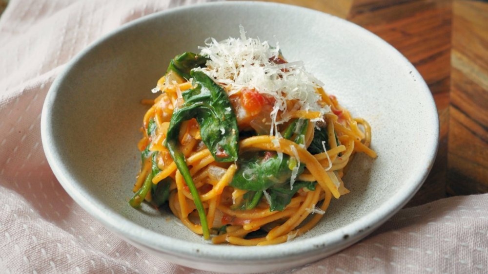 One-pot pasta with spinach and tomatoes in bowl