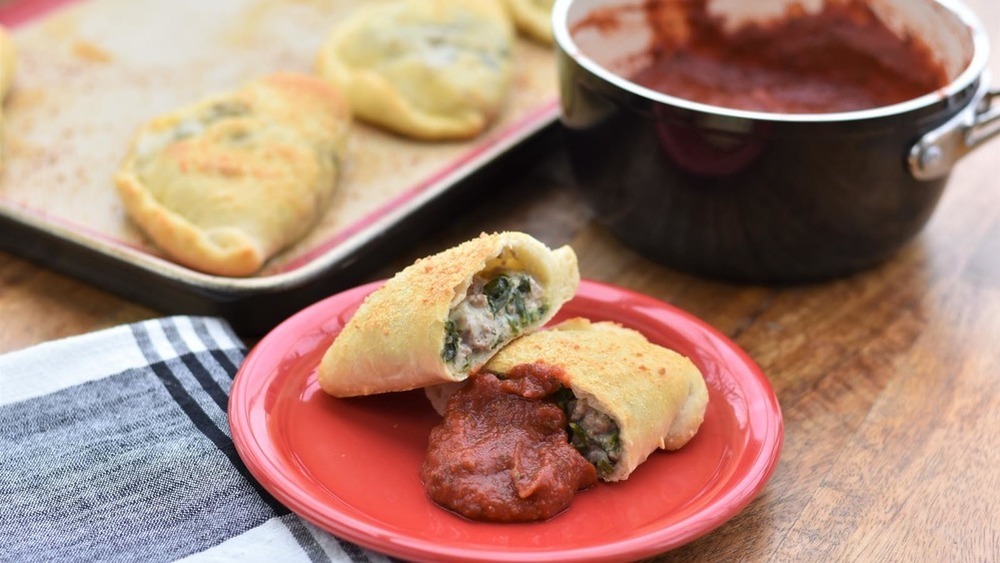 homemade calzones with spinach, sausage and marinara sauce