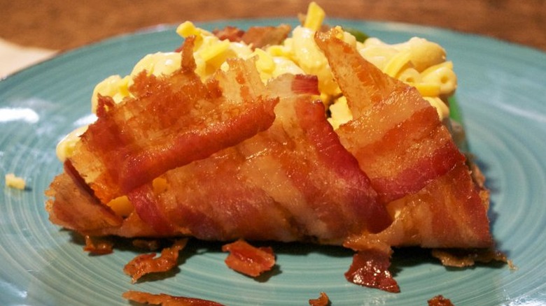 Mac and cheese inside a shell of bacon strips.