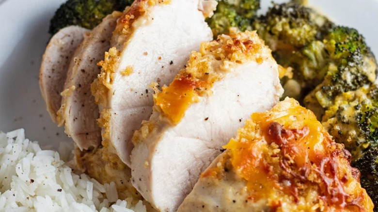 Baked chicken with cheese topping and broccoli.