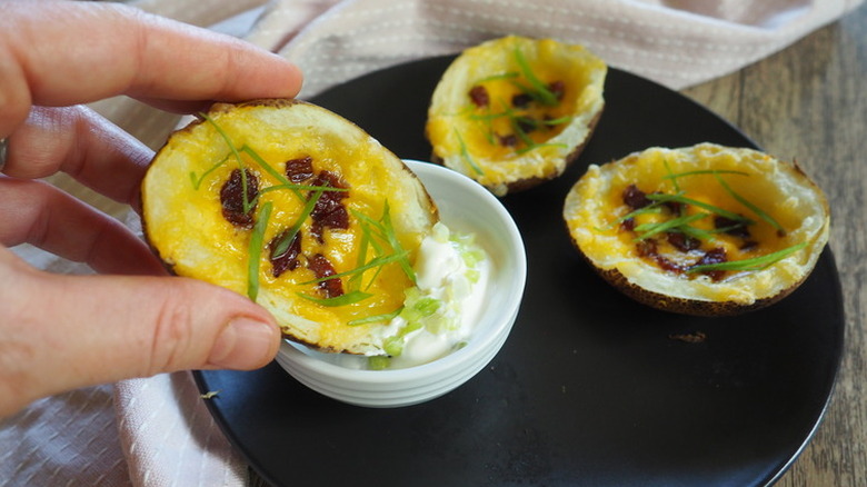 Baked potato skins with melted cheese and dip.