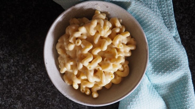 Cavatappi pasta in cheese sauce in white bowl. 