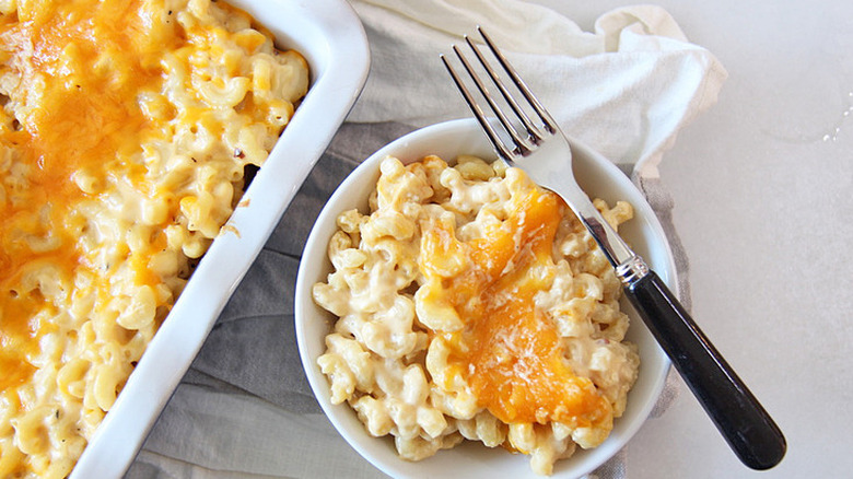 Pan and small bowl of baked mac and cheese.