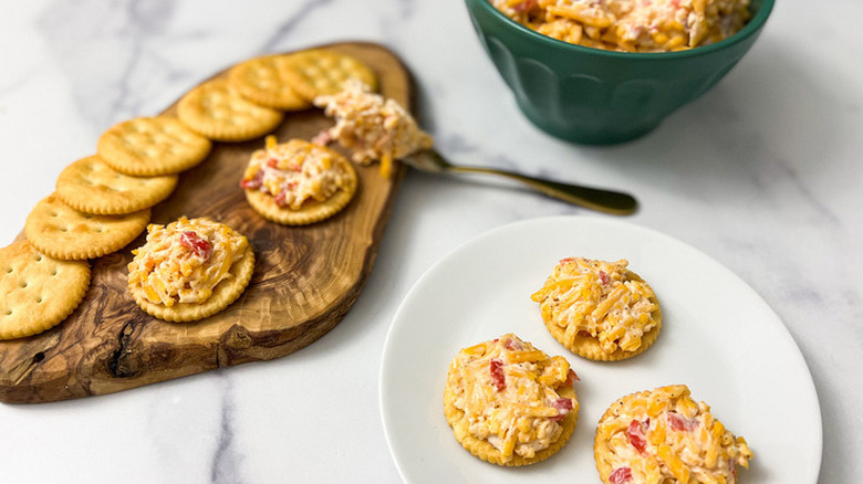 Pimento cheese spread on crackers and in bowl. 