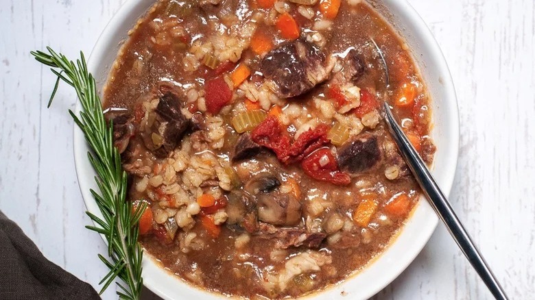 bowl of instant pot beef barley soup with spoon