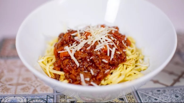 bowl of instant pot bolognese topped with cheese