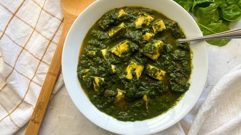 bowl of Instant Pot Saag Paneer with wooden spoon