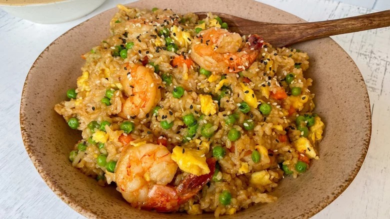 bowl of instant pot shrimp fried rice with wooden spoon