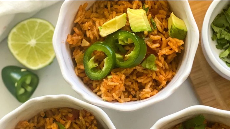 bowls of instant pot spanish rice with jalapenos and limes