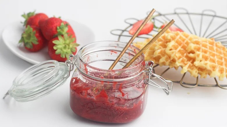 jar of strawberry compote with strawberries and waffles