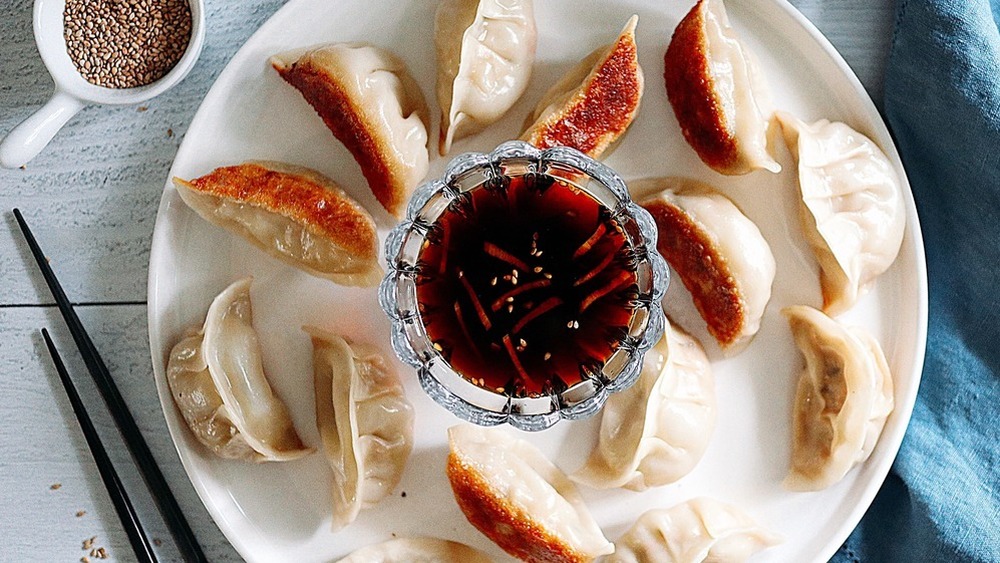 Spicy chicken potstickers on a platter with sauce