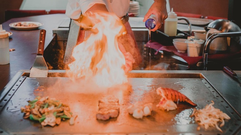 A chef at Tanaki preparing meats on the grill