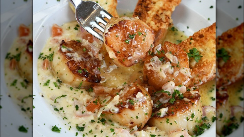 Scallops with sauce and fork