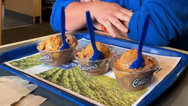 man sitting in front of three Culver's ice creams