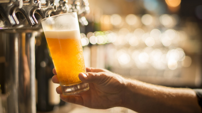 pouring beer into a pint glass