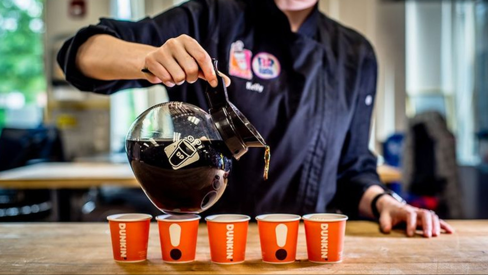 Barista pouring Dunkin' coffee