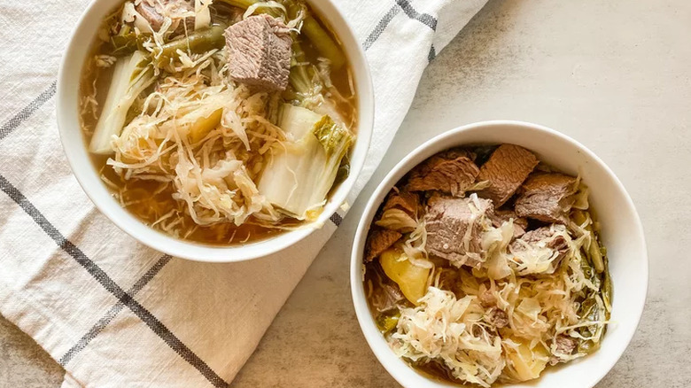 Two bowls of beef stew with cabbage and bok choy.