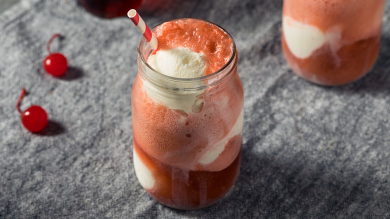an ice cream float made with cherry cola and vanilla ice cream in a mason jar