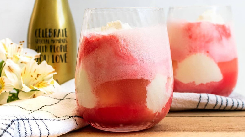 A wine glass full of champagne, fruit juice, and vanilla ice cream