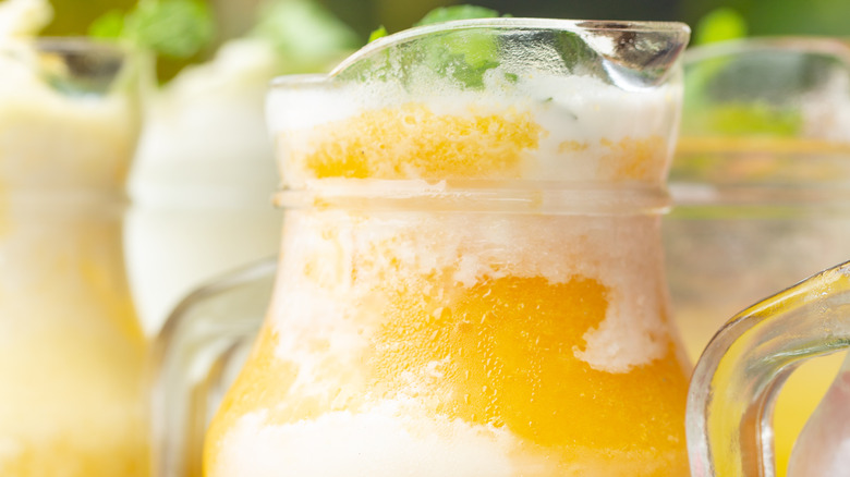 a small pitcher of mango ice cream float made with mango nectar juice, club soda, and vanilla ice cream