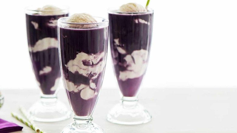 glasses of vanilla ice cream and concord grape juice as a purple cow float smoothie