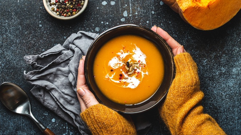 woman holding butternut squash soup