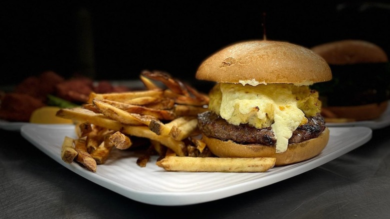 Hamburger and French fries on a plate.