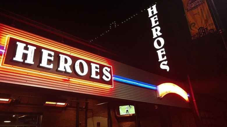 Outside of Heroes bar lit up with neon signs