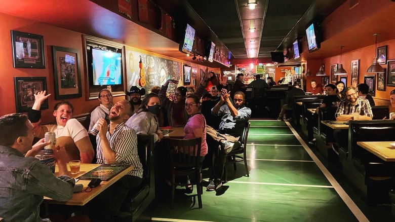 A crowded bar with people laughing and smiling 