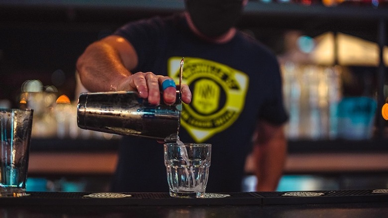 Bartender pouring a drink into a glass